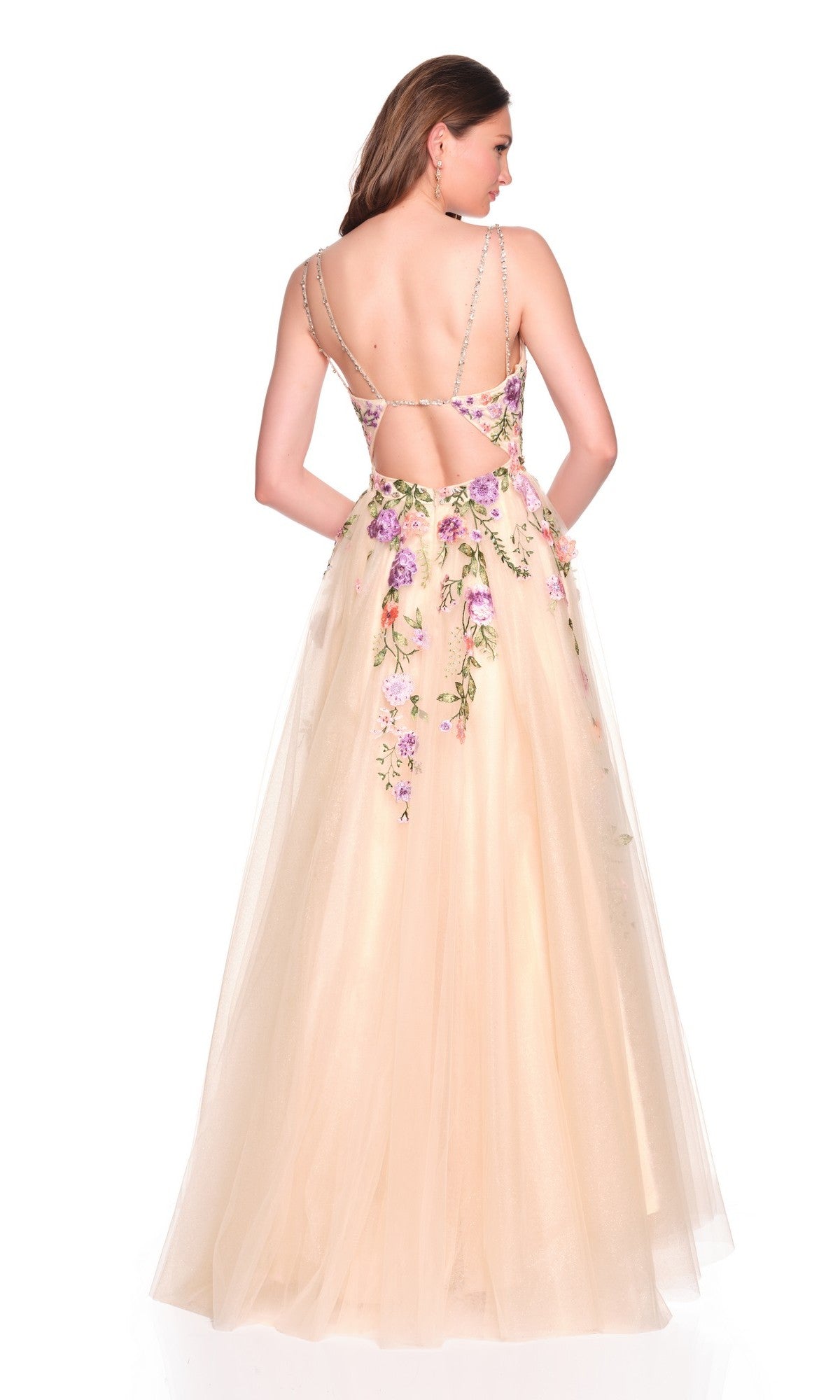 A woman wears the Long Prom Dress: Dave and Johnny 12479, a cream-colored dress with floral embroidery, thin shoulder straps, and an open back, standing against a white background.